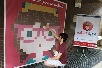 Aluno do Icomp deixando mensagem no mural do Cunhantã Digital em homenagem ao Dia da Mulher