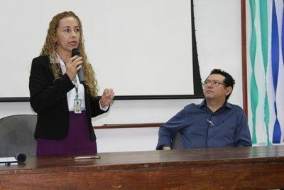 Professora Irlane Maia fala ao público no Fórum, observado pelo coordenador Nilomar Vieira 