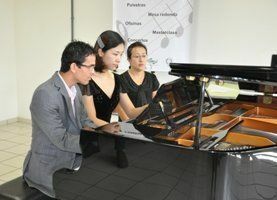 Pianistas e paginista durante o concerto a quatro mãos